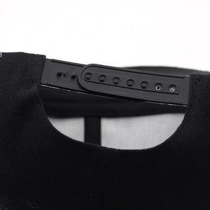 Détail de la fermeture snapback réglable sur une casquette hip-hop noire ornée de clous