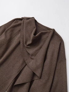 Detail of dark brown knitted coat collar and fine fabric texture on grey background