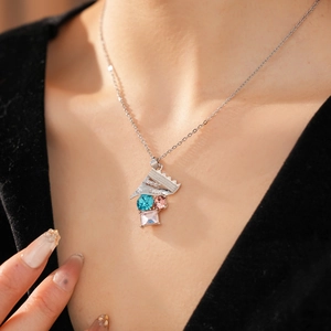 Nahaufnahme einer Silberkette mit blau-rosa Kristallen und Sweet-Gravur am Model