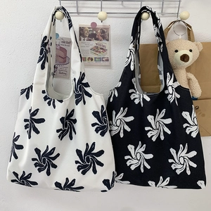 Close-up of floral print canvas tote bags in black and white with minimalist aesthetic