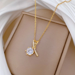 Collier doré avec pendentif cœur croisé et zircon rond sur un présentoir en soie