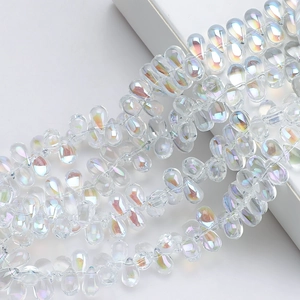 Macro shot of 6x9mm teardrop glass beads with iridescent electroplated finish for DIY crafts