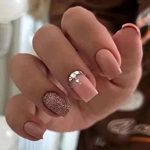 Detail of pinkish-brown square press-on nails with half-moon rhinestones and gold glitter