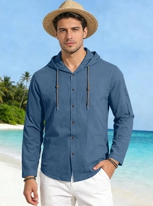 Detail of blue long-sleeved hooded cotton shirt with buttons in a beach holiday setting