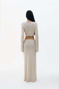 Vue arrière de l'ensemble en tricot crème avec haut court à manches longues et jupe longue