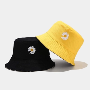 Reversible daisy embroidered cotton bucket hats in black and yellow for sun protection