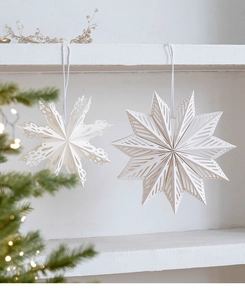 Détail d'étoiles de Noël 3D en papier blanc avec motifs géométriques nordiques évidés