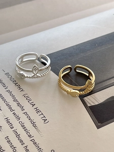 Detail of adjustable S925 silver and gold fish-shaped rings with micro-pave crystals