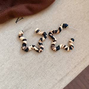 Macro detail of star-shaped hoop earrings with retro leopard print and twisted texture