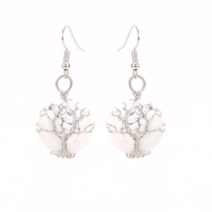 Detailed view of handmade silver wire-wrapped tree of life earrings with white turquoise