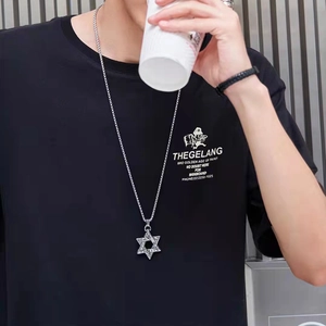 Close-up of a vintage hexagram star pendant with detailed texture on a long silver chain