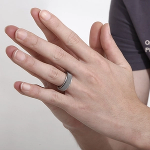 Close-up of a rotating men's titanium ring featuring an intricate mesh weave pattern