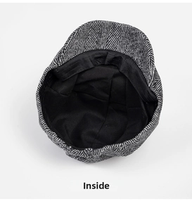 Internal detail of newsboy hat showing black lining and textured herringbone fabric