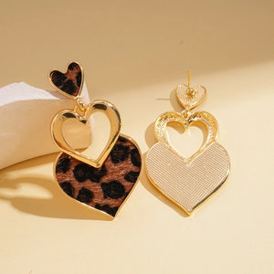 Close-up of triple heart leopard print earrings with gold-tone borders and studs