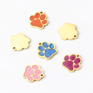 Close-up of colorful glitter paw-shaped pet tags in orange blue pink and purple