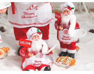 Close-up of Santa Claus chef figurine with Merry Christmas apron and candy cane detail
