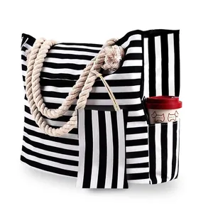 Macro detail of large striped canvas tote with braided rope handles and small pouch