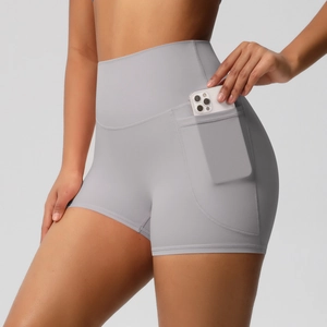Détail du short de yoga taille haute avec une poche latérale contenant un téléphone