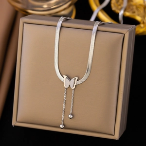 Macro shot of silver butterfly pendant with tassel beads on a flat snake chain