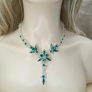 Detail of silver bridal necklace featuring emerald green crystals and floral design