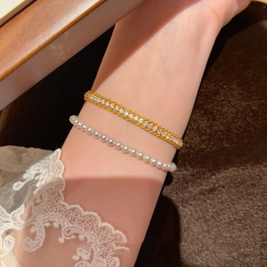 Détail de l'ensemble bracelet en or avec zircons cubiques et rang de perles blanches