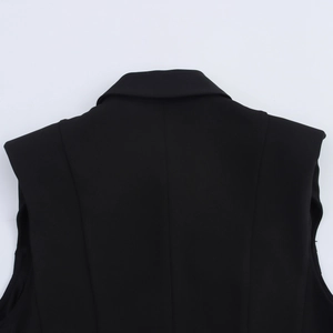 Detail of shoulder pad and collar stitching on women's sleeveless black blazer dress