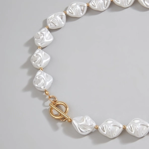 Detail of baroque pearl necklace with irregular white pearls and a golden OT clasp