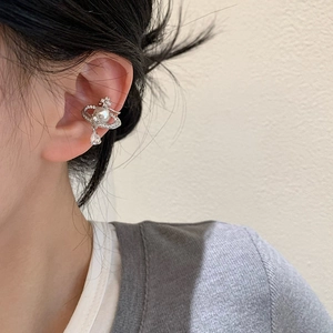 Detail of Saturn-shaped ear cuff with pearls and zircon drop pendant on ear