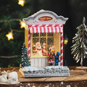 Illuminated Christmas candy shop snow globe with Santa Claus and warm festive lights