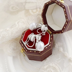 Detail of vintage silver pearl clip-on earrings with soft silicone pads in a red gift box