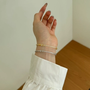 Detailed view of Mobius silver bracelets with opal and zircon stones on model's wrist