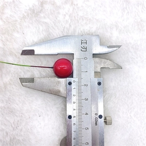 Measuring a 12.5mm red artificial berry ornament with a metal vernier caliper