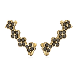 Detailed macro view of gold-plated clover ear climbers with black crystal inlay