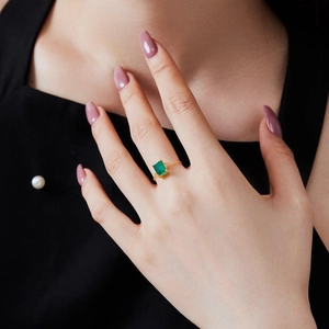 Detailed close-up of a golden adjustable chain ring featuring a green zircon gemstone