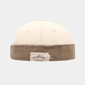 Detail der Vintage-Miki-Mütze mit beige-braunem Patchwork und besticktem Aufnäher