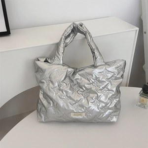 Close-up of silver quilted tote bag with floral embossing and Sozakka brand label