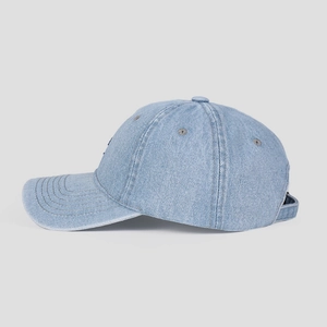 Detail of light blue denim baseball cap showing side profile and textile texture