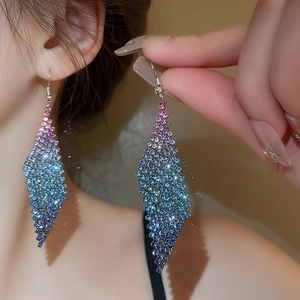 Détail de boucles d'oreilles pendantes à pampilles en strass avec dégradé rose et bleu