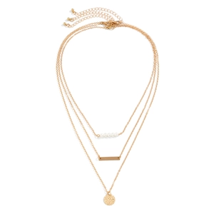 Detailed close-up of triple-layered gold chain necklace with pearls and metal pendants
