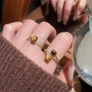 Close-up of gold-plated tiger eye rings with zircon accents in vintage planet design