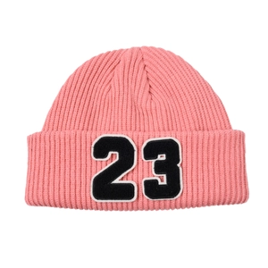 Detalle del gorro de punto rosa acanalado con parche bordado del número 23 en contraste