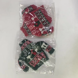 Detail of red and green knitted Christmas wine bottle covers with reindeer and snowflake patterns