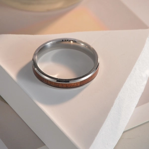Macro detail of 4mm titanium steel ring with koa wood inlay on geometric stone base