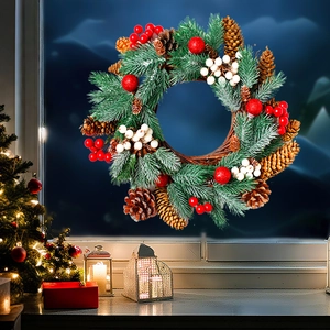 Close-up of Christmas wreath with pine cones and red berries on a window pane