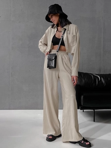 Detail of beige long-sleeve crop shirt and drawstring wide-leg pants with linen texture