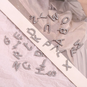 Detailed view of silver twisted rope texture A-Z alphabet pendants on soft fabric