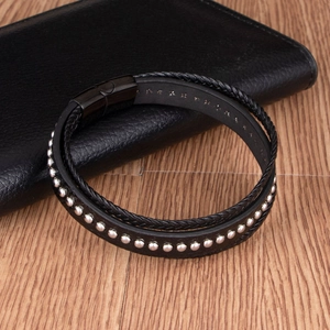 Bracelet multicouche en cuir noir avec rivets argentés et fermoir magnétique sur bois