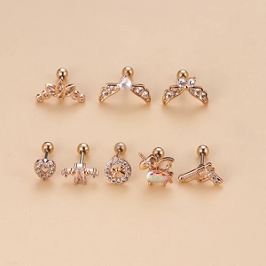 Close-up of rose gold stainless steel stud earrings set with heart and wing shapes