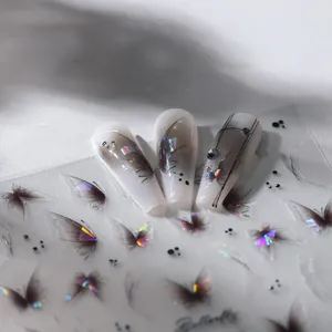 Vue macro de stickers 3D papillon pour ongles avec dégradé doré et détails en strass