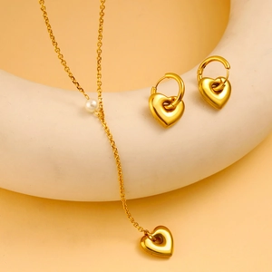 Elegant 18K gold-plated heart necklace and earrings set with white pearl on beige stand